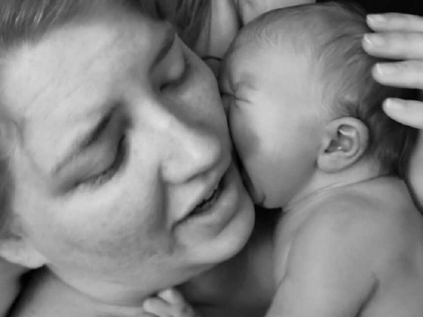 Mother holds newborn against her cheek